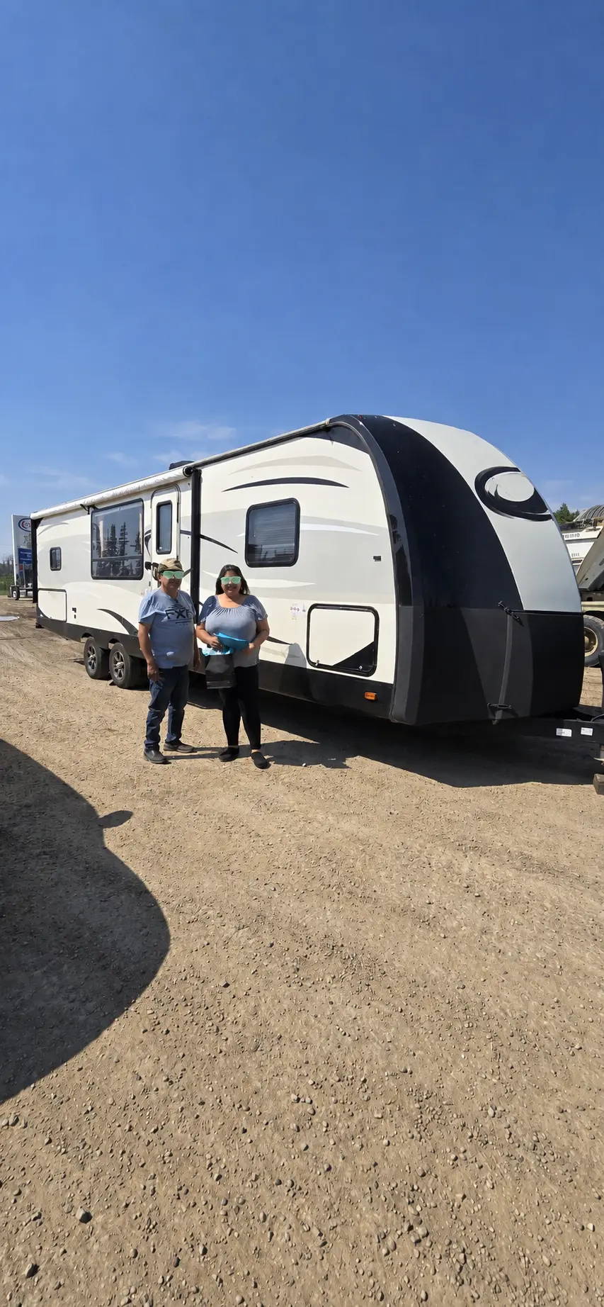A couple in front of their new travel trailer